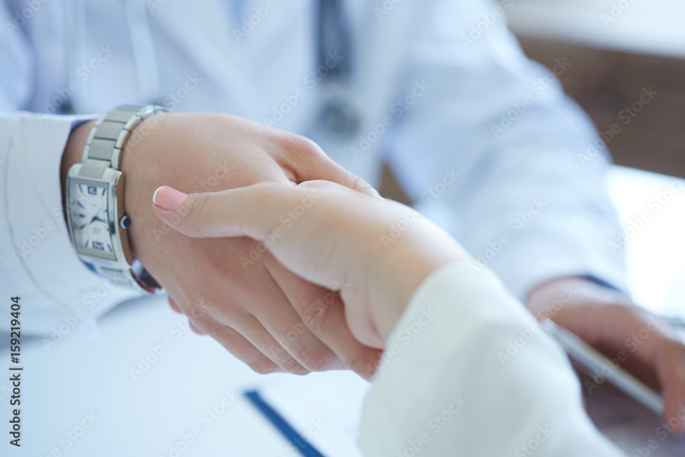 Male doctor shaking hands with patient. Partnership, trust and medical ethics concept. Handshake with satisfied client. Thankful handclasp for excellent treatment.
