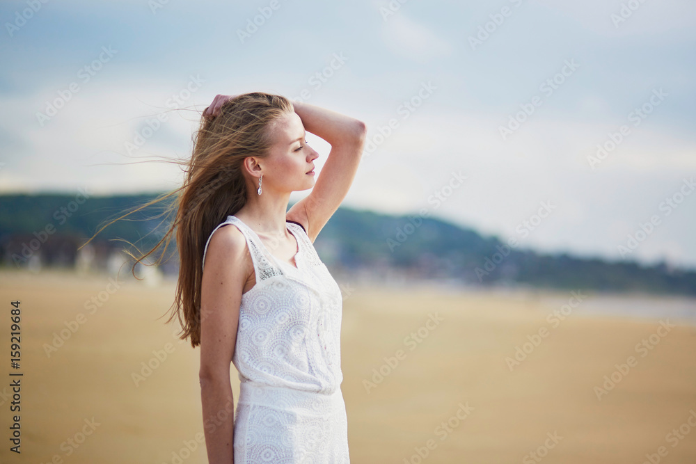 Beautiful young woman enjoying sun on a sand beach Beautiful young woman enjoying sun on a sand beach