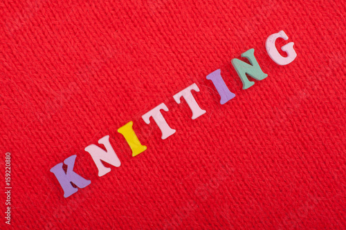 Knitting. Knitted Fabric Texture. Word composed from ABC alphabet letters on red background.