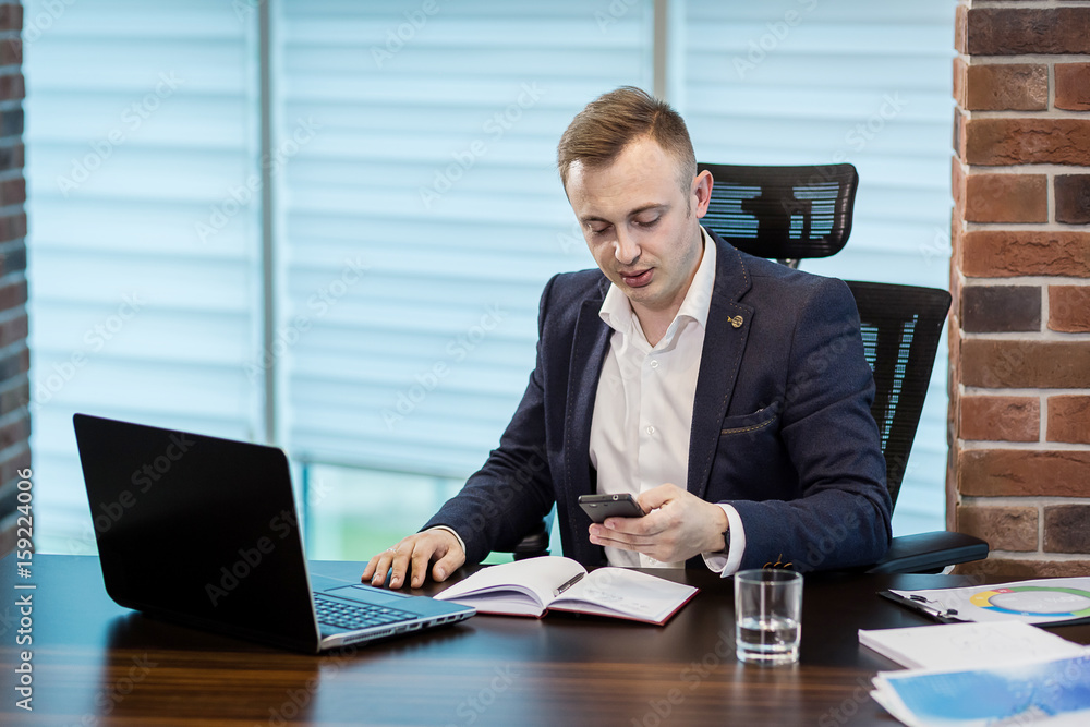 Businessman holding a cell phone and writing sms message in office,businessman use mobile smart phone,Close up of a man using mobile phone,Young businessman working with modern devices mobile phone. Businessman holding a cell phone and writing sms message in office,businessman use mobile smart phone,Close up of a man using mobile phone,Young businessman working with modern devices mobile phone.