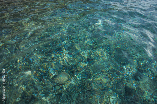 Sea water and stones at the bottom photo