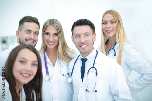 Smiling team of doctors at hospital making selfie.