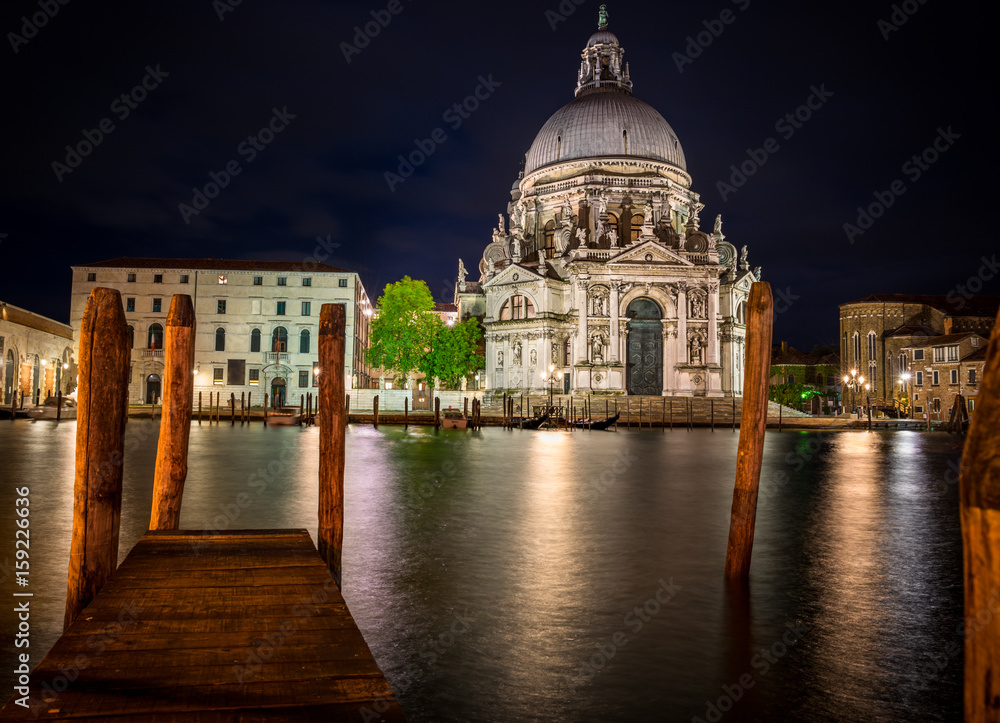 Ornate facade of the Santa Maria della Salute Church, Venice, illuminated at night, built by the Ventians to offer thanks for surviving the Plague