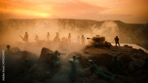 War Concept. Military silhouettes fighting scene on war fog sky background, World War Soldiers Silhouettes Below Cloudy Skyline At night. Attack scene. Armored vehicles. Tanks battle © zef art