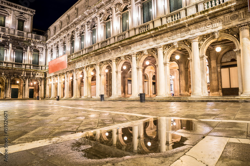  Night view of San Marco with reflecion in reflection in a puddle. Venice, Italy