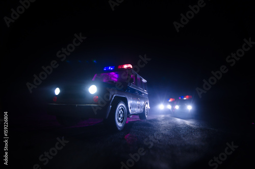 speed lighting of police car in the night on the road. Police cars on road moving with fog. Selective focus. Chase
