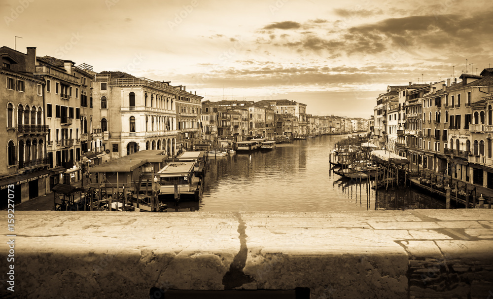 Naklejka premium Vintage and panoramic view on famous Grand Canal among historic houses in Venice, Italy at sunrise. Picture took from the Rialto bridge.