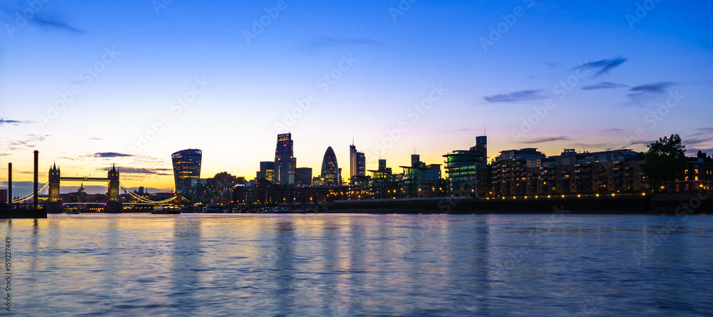 London skyline at dusk including Tower Bridge and skyscrapers at financial district