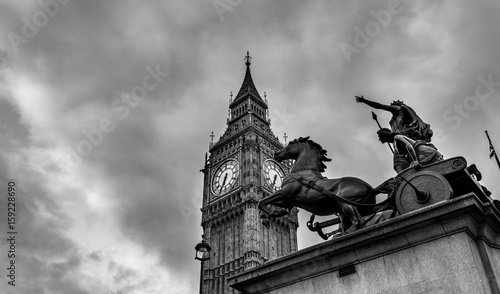 Big Ben and statue of Boadicea and Her Daughters in Westminster London. Black and white picture with dramatic sky. photo