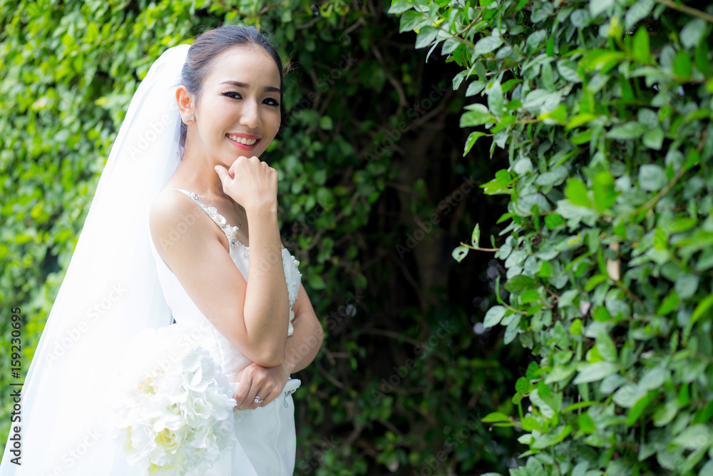beautiful young woman on wedding day in white dress in the tree wall. Female portrait in the park - Selective focus beautiful young woman on wedding day in white dress in the tree wall. Female portrait in the park - Selective focus