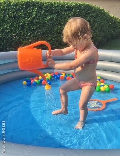 Tableau sur toile bambina gioca nella piscina gonfiabile in giardino