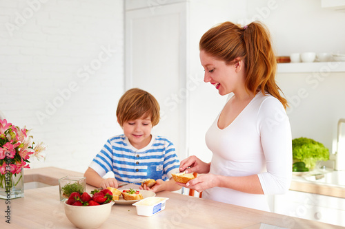 happy mother and son preparing snacks in the morning at home kitchen