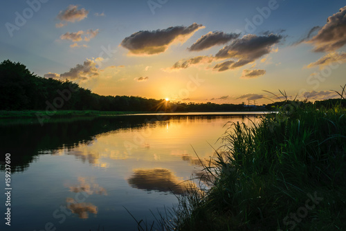 Fototapeta Naklejka Na Ścianę i Meble -  Sunset and clouds reflected in a lake