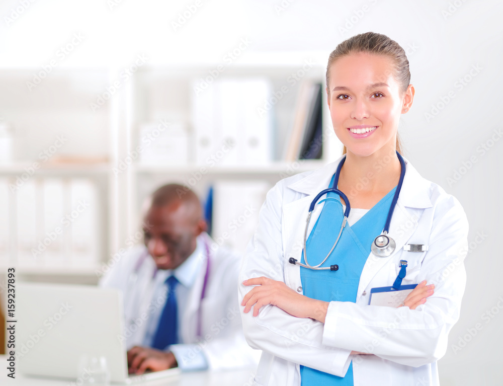 A smiling female doctor with a folder in uniform indoors A smiling female doctor with a folder in uniform indoors