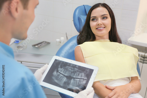 Dentist looking at X-ray im...