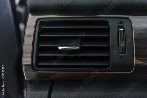 Car air conditioning system grid panel on console. Auto interior detail.