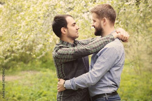 Happy gay couple hugging on blurred background © Africa Studio