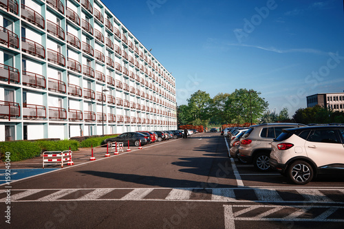 Modern building and car parking zone on sunny day