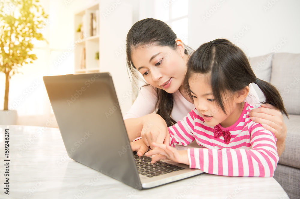 mother teaching her daughter computer