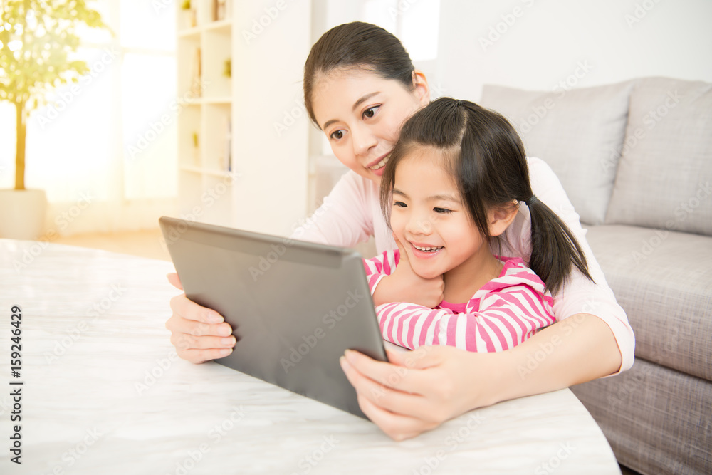 mother and daughter looking in digital tablet mother and daughter looking in digital tablet