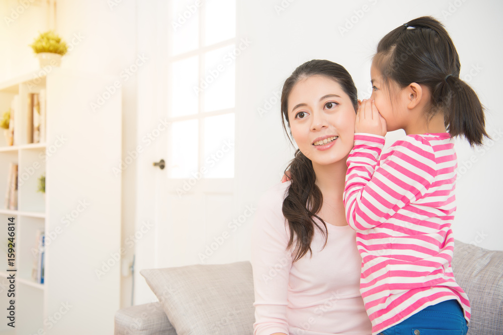 Daughter whispering to mom a secret Daughter whispering to mom a secret