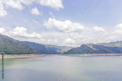 Landscape of natural dam mountain and water reservoir under cloudy sky, natural irrigation system.