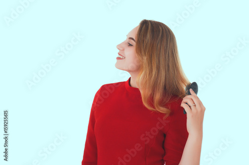 Young pretty woman uses hairbrush  