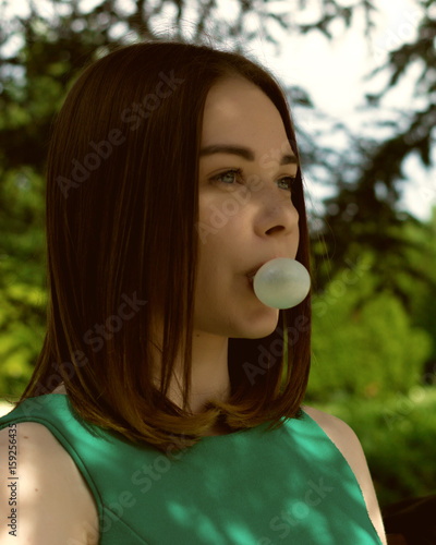 Young pretty girl chews a gum, outdoor  