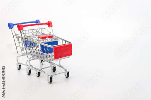 mini supermarket shopping cart blue and red color on white background, holiday sale and online shopping concept, selective focus, copy space © Vittaya_25