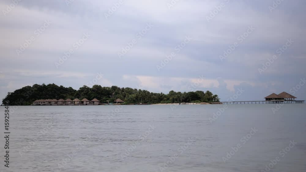 distance view of luxury resort and bungalows on a tropical island distance view of luxury resort and bungalows on a tropical island
