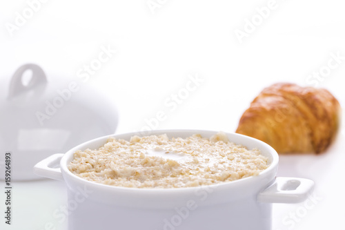 Oat porridge in a white saucepan. Oatmeal. Cap..