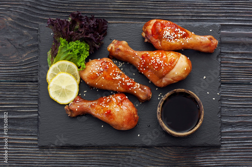 Baked chicken drumsticks served on a stone slate