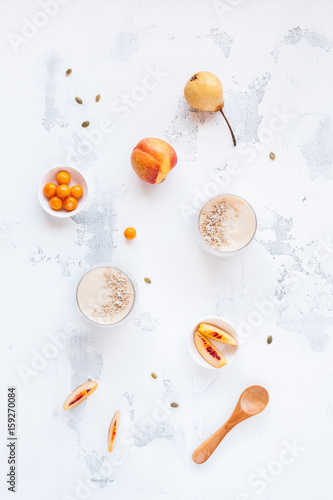 Breakfast with peach yogurt, sliced peaches, physalis on white background. Flat lay, top view