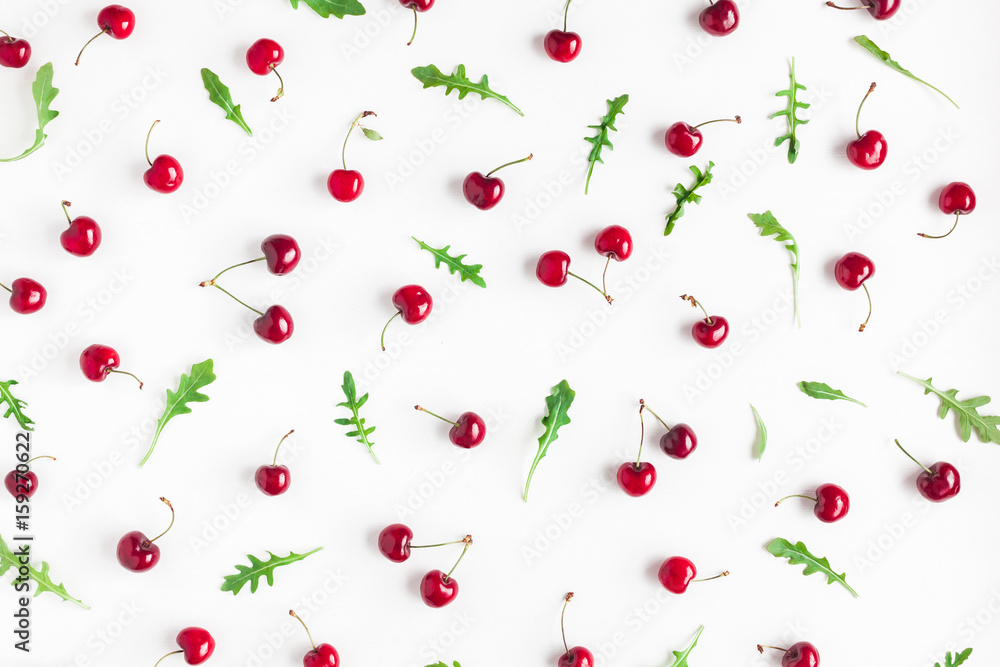 Cherry pattern. Fresh sweet cherry and arugula leaves on white background. Flat lay, top view Cherry pattern. Fresh sweet cherry and arugula leaves on white background. Flat lay, top view