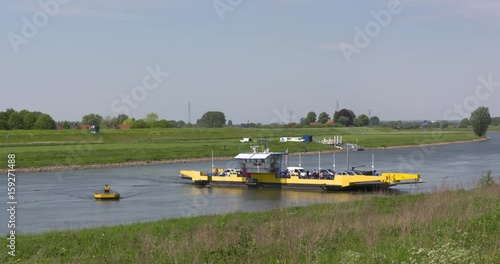 Ferry Willem across the Pannerden Canal. The canal cuts off a large, shallow bend of river Rhine and so improves river traffic and water regulation. PANNERDEN, THE NETHERLANDS, MAY 2017 photo