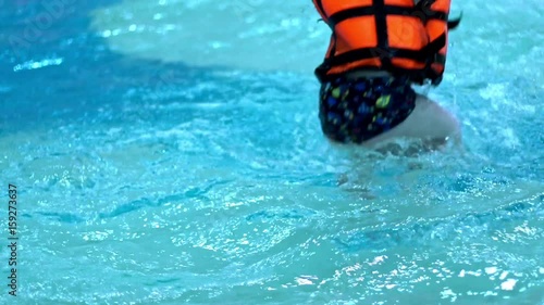 Children playing in water swimming pool slow motion. Child in swimming pool