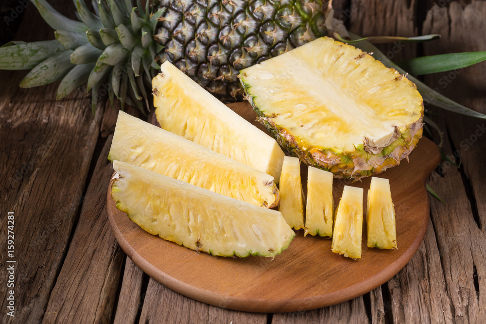 Ripe pineapple and pineapple slices on a wooden background tropical fruits Ripe pineapple and pineapple slices on a wooden background tropical fruits