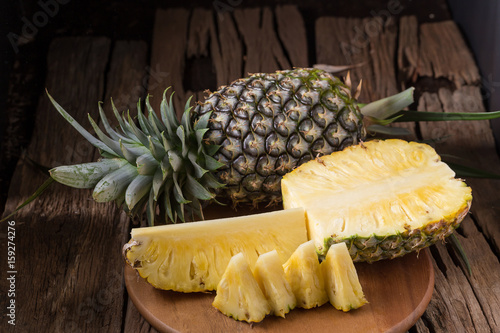 Ripe pineapple and pineapple slices on a wooden background tropical fruits