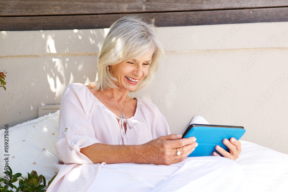 smiling older lady with digital tablet outside smiling older lady with digital tablet outside
