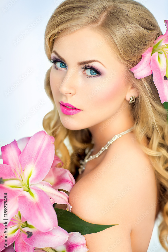 Beautiful woman portrait with flowers on head and in hands. Young lady posing on white background. Gorgeous make up. Magnetic view. Glamour lipstick.