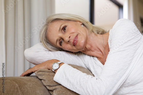 Close up relaxing older woman sitting on sofa at home