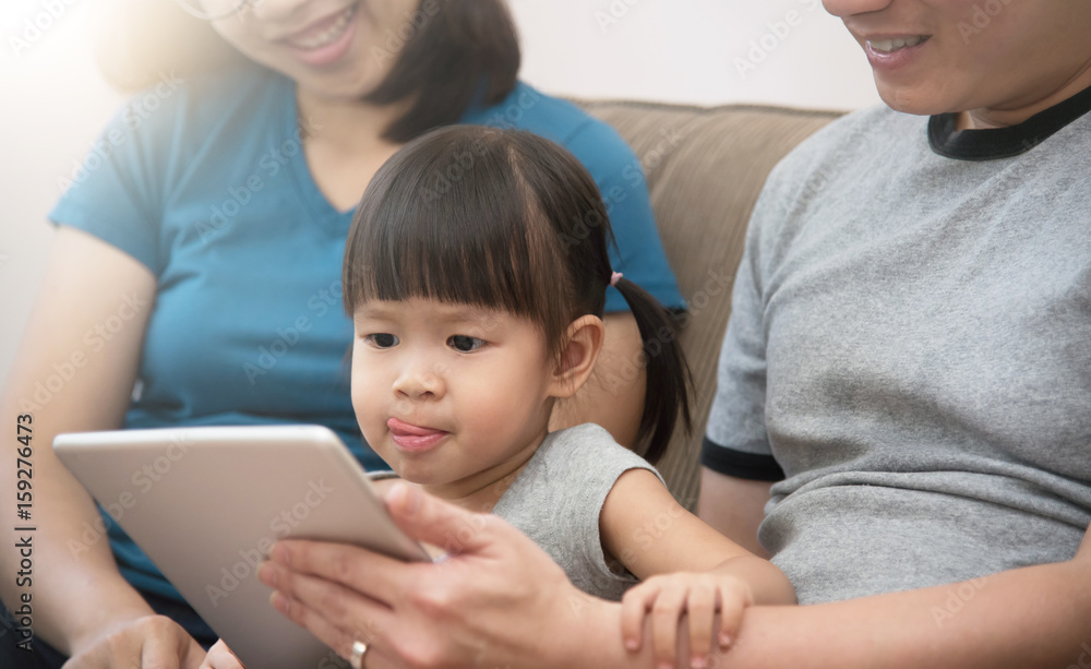 Happiness of Asian family sitting and playing digital tablet together. Happiness of Asian family sitting and playing digital tablet together.