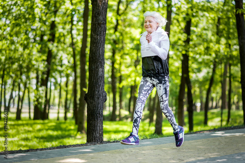 Happy aged sporty woman running