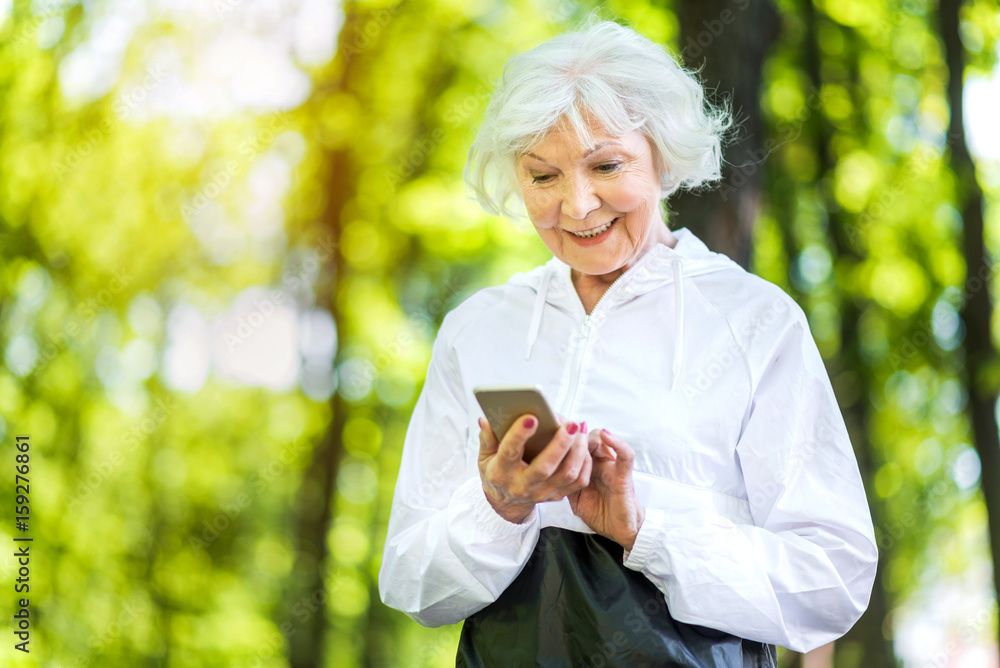 Happy elderly lady resting after exercise in park Happy elderly lady resting after exercise in park