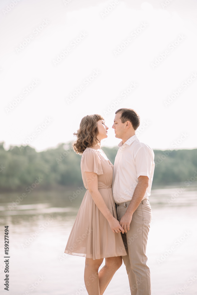 love story, beautiful couple a man and a woman in bright clothes, happy family, walking along the river Bank,standing holding hands, looking at each other, hugging, summer, nature love story, beautiful couple a man and a woman in bright clothes, happy family, walking along the river Bank,standing holding hands, looking at each other, hugging, summer, nature