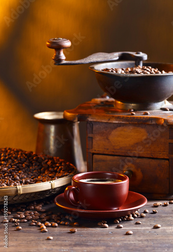 Cup of black coffee , coffee grinder and roasted beans