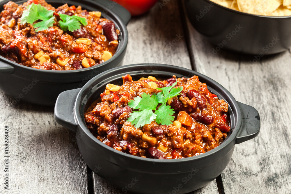 Bowls of hot chili con carne with ground beef, beans, tomatoes and corn Bowls of hot chili con carne with ground beef, beans, tomatoes and corn