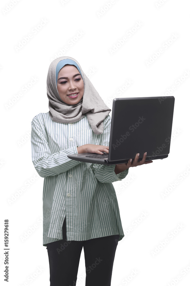 Beautiful asian muslim woman holding while typing on laptop Beautiful asian muslim woman holding while typing on laptop