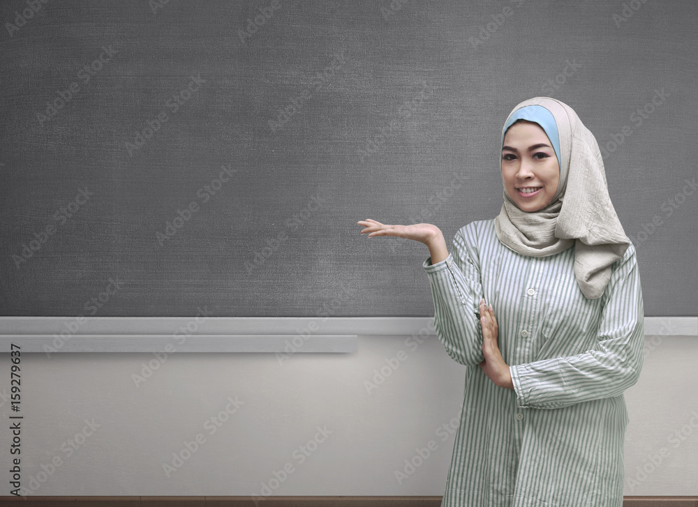 Beautiful asian muslim woman wearing hijab showing copyspace area