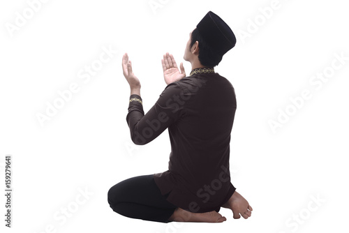 Back view of asian muslim man with cap praying
